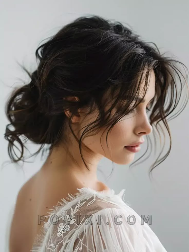 a woman with wavy hair wearing a white dress and looking off to the side in profile