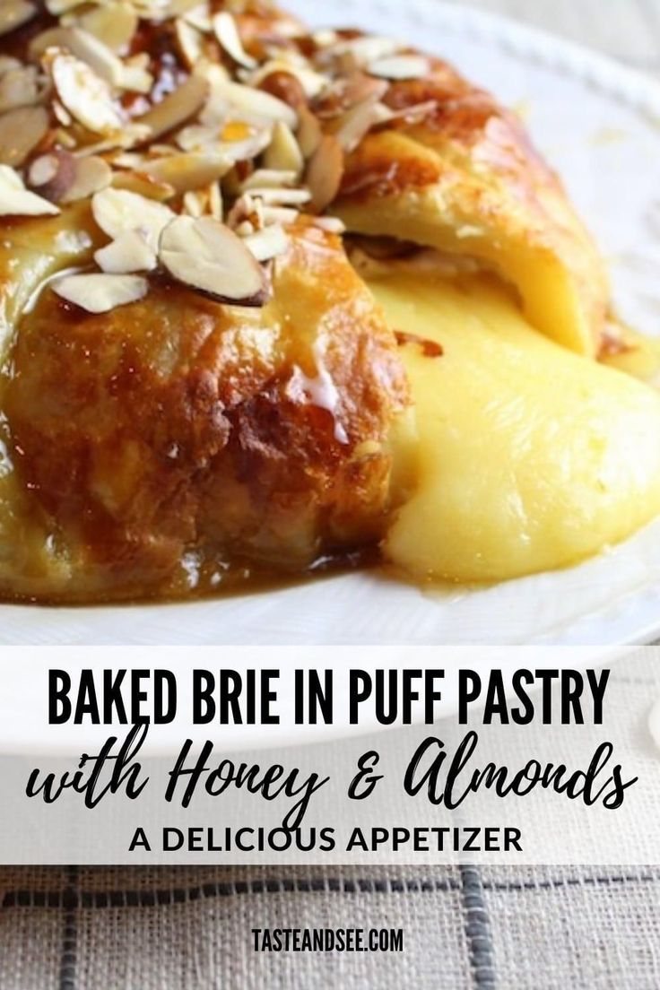 baked brie in puff pastry with honey and almonds on a white platter