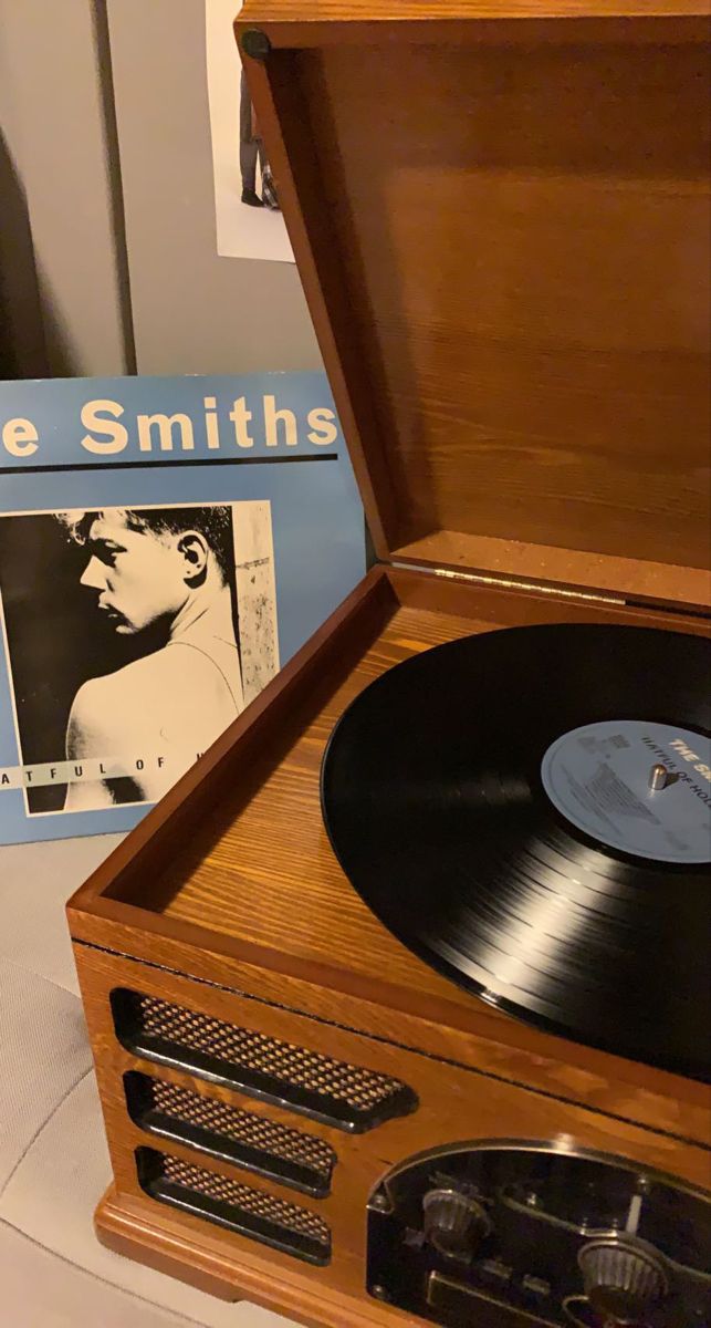 an old record player sitting on top of a table next to a box with vinyl records in it