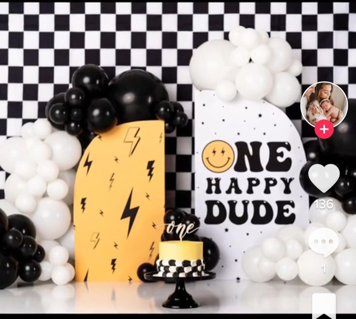 a table topped with balloons and cake next to a black and white checkered wall