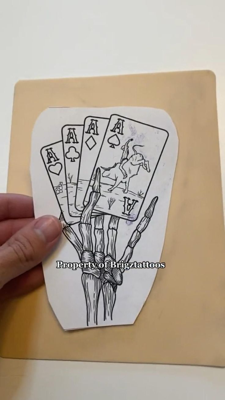 a hand is holding up some playing cards