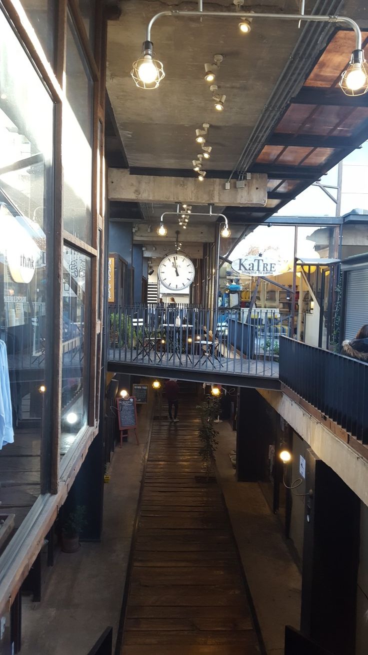 the inside of a building with lots of windows and lights hanging from it's ceiling