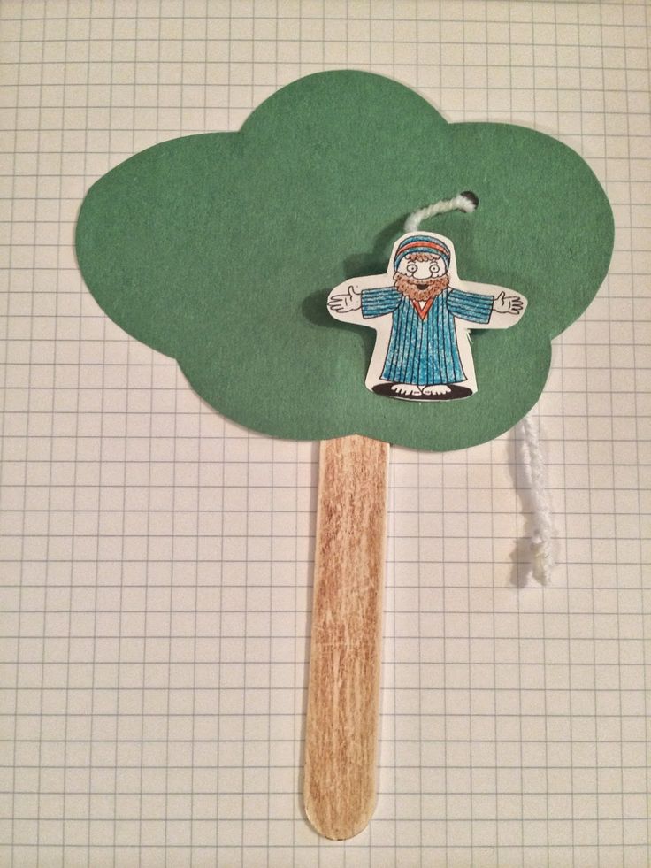 a wooden stick with a paper cut out of a man holding a cross on it