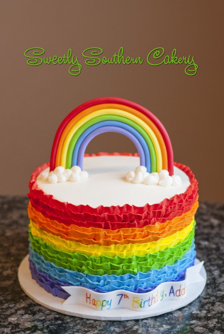 a rainbow cake with white frosting and icing