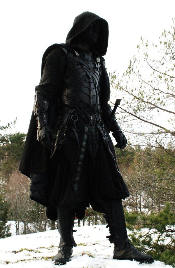 a man dressed in black standing on top of snow covered ground