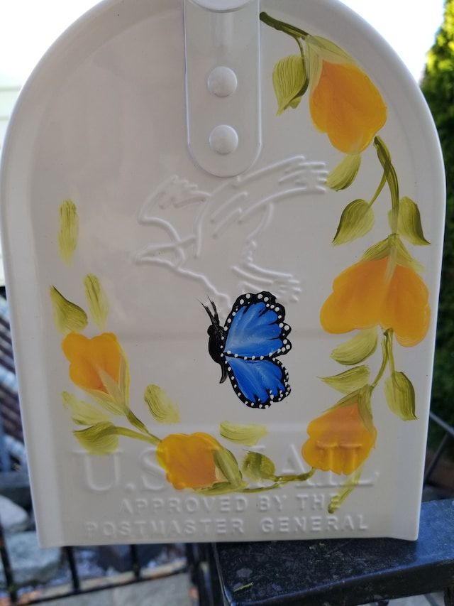 a white mailbox with a blue butterfly painted on it