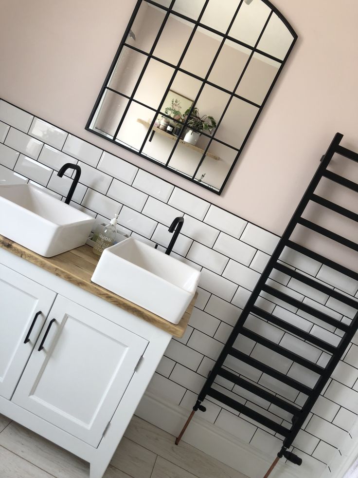 two white sinks sitting under a mirror in a bathroom next to a radiator