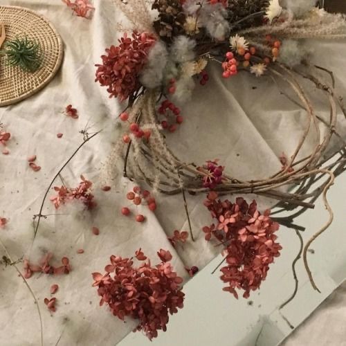 dried flowers and branches on a table with other things to make it look like they are floating in the air