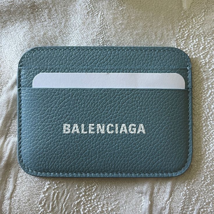 Grained Calfskin Card Holder In Blue. Logo Printed In White At Face. Four Card Slots And One Central Note Slot. Silver-Tone Logo Stamp At Interior. Tonal Calfskin Lining. Approx. 4 Length X 3 Height. Supplier Color: Blue Grey Brand New. Balenciaga Blue, Blue Logo, Logo Stamp, Key Card Holder, Card Holders, Calf Skin, Slots, Card Slots, Blue Grey