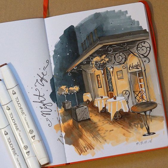 an open notebook with a watercolor drawing of a restaurant and two pens next to it