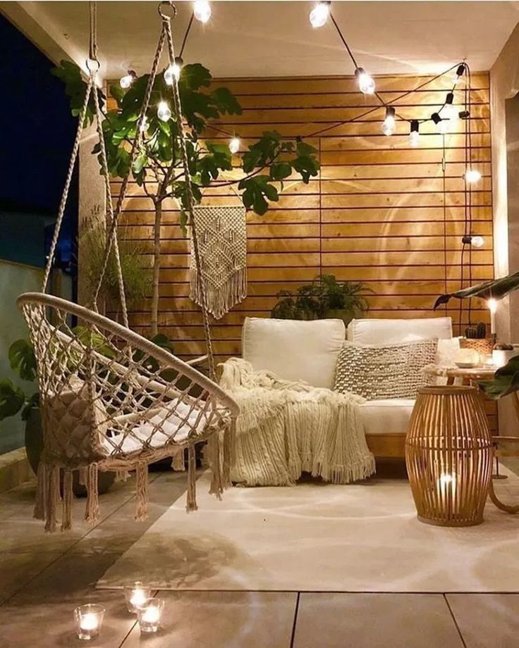 an outdoor living area with lights and plants on the wall, hanging from strings above