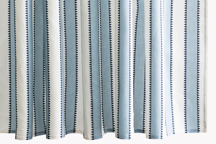 blue and white striped curtains hanging on the side of a window