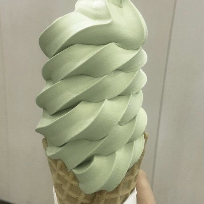 a green ice cream cone sitting on top of a white plate