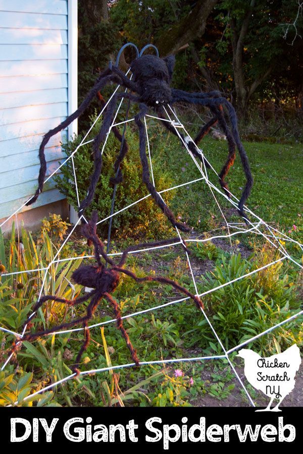 a giant spider made out of wire sitting on top of a grass covered yard with the words diy giant spider web