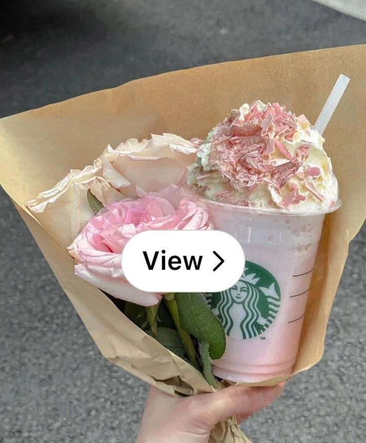 a starbucks cup with pink flowers in it and the words view above it are written