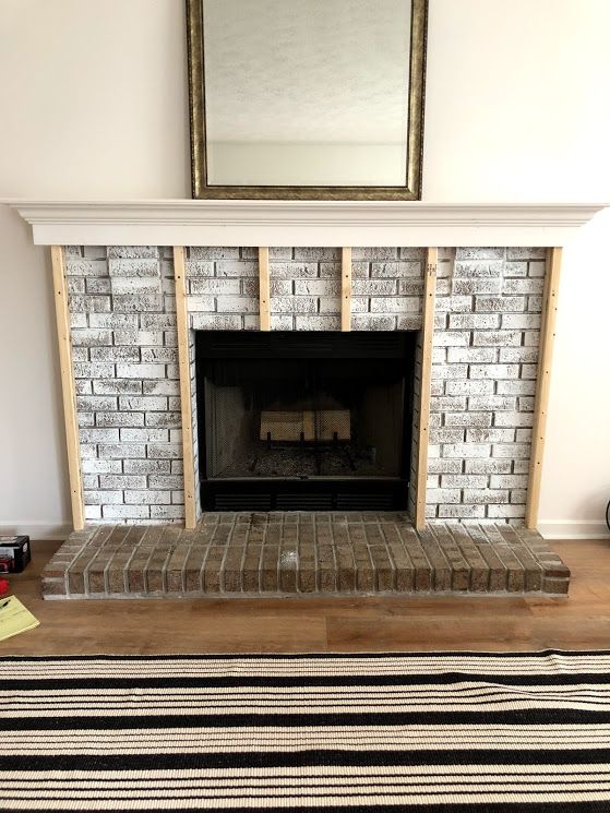 a living room with a fire place and rug on the floor