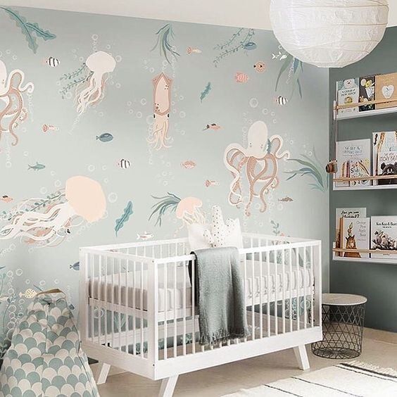 a baby's room with an ocean theme wallpaper