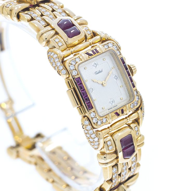 Pre-owned in very good condition Lady’s Tabbah Saga de Tabbah collection known for its unique and modern style, this amazing Swiss-made watch features an elegant rectangular case crafted from precious 18K Yellow Gold and measures approximately 25mm (from end of case to end of crown) x 6.5mm (high). The case is topped with an amazing Diamond-studded 18K Yellow Gold bezel and Rubies approximately 4.87 cts. Behind the high-quality crystal is a superb White guilloche dial with applied dots hour mark Formal Yellow Gold Diamond Watch With Rectangular Shape, Luxury Hallmarked Evening Watches, Rectangular Yellow Gold Diamond Watch, Luxury Hallmarked Diamond Watch For Evening, Designer Diamond Watch With Yellow Gold Rectangular Dial, Luxury Hallmarked Diamond Watch For Evenings, Designer Yellow Gold Diamond Watch With Rectangular Dial, Yellow Gold Rectangular Diamond Watch For Evening, Rectangular Yellow Gold Jewelry With Diamond Hour Markers