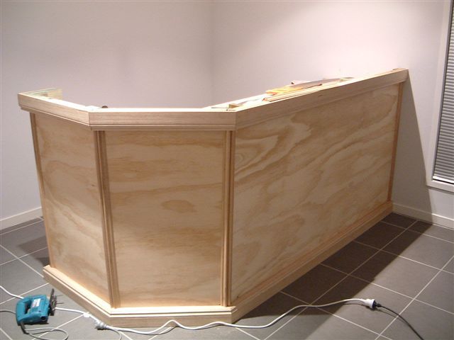 a wooden counter sitting on top of a tiled floor