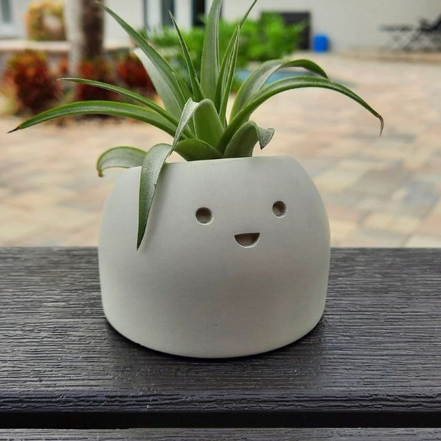 a white planter sitting on top of a wooden table