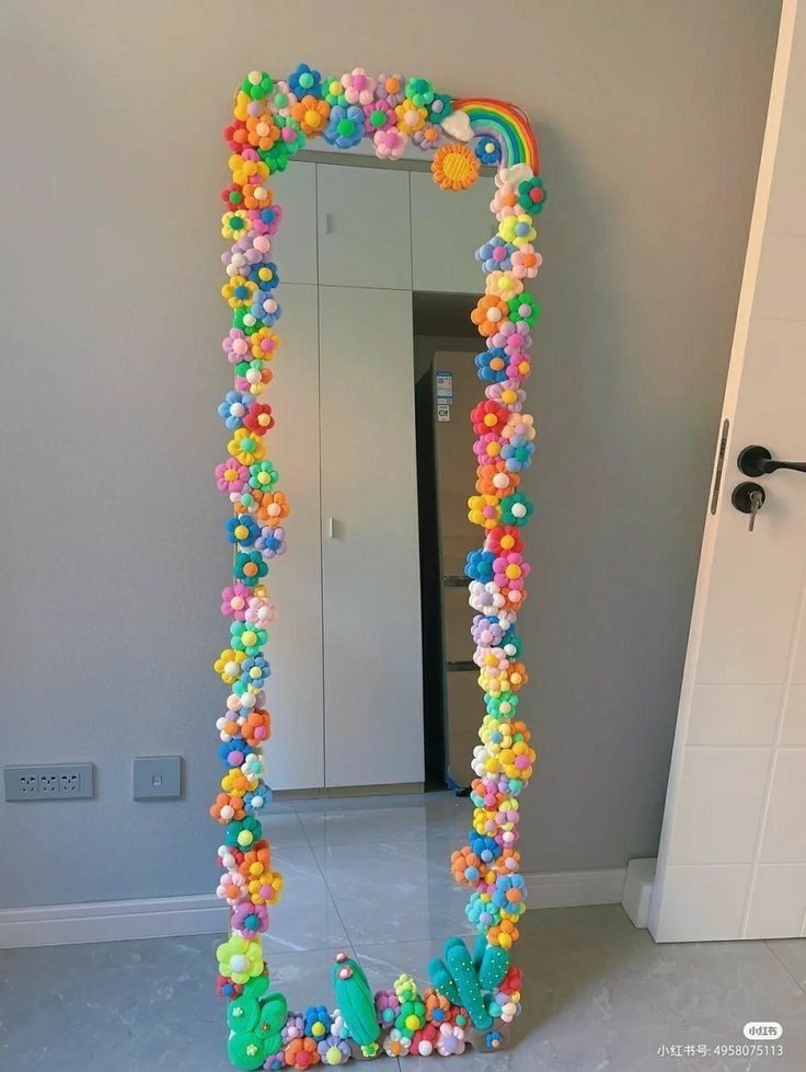 a large mirror decorated with colorful beads and candy balls in the shape of a rainbow