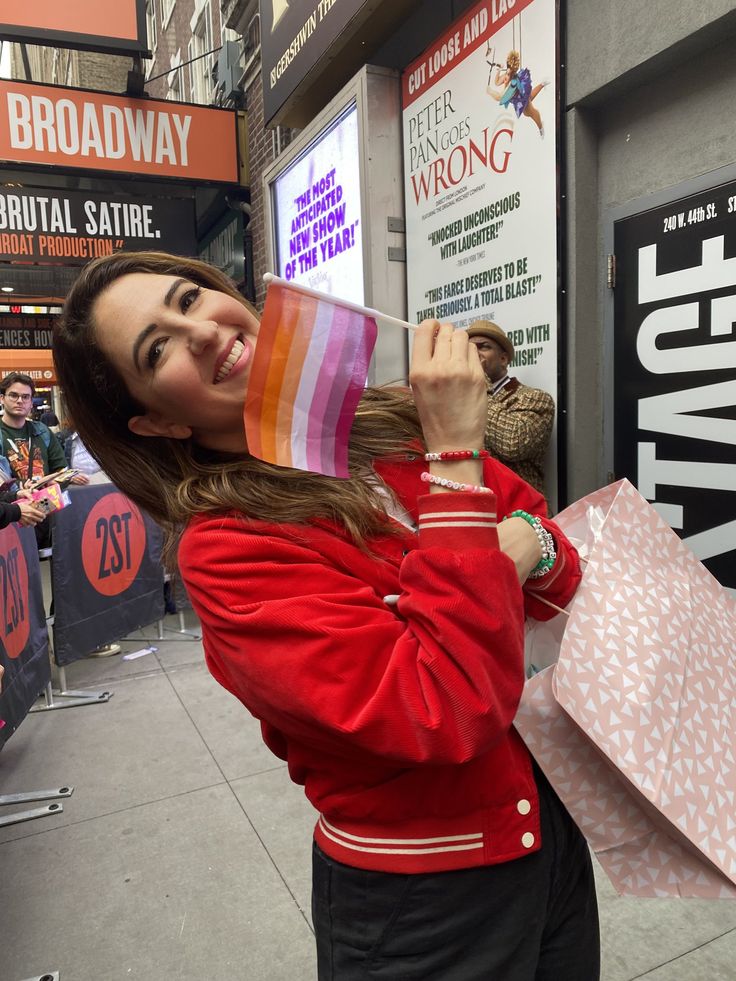 a woman in a red jacket is holding shopping bags