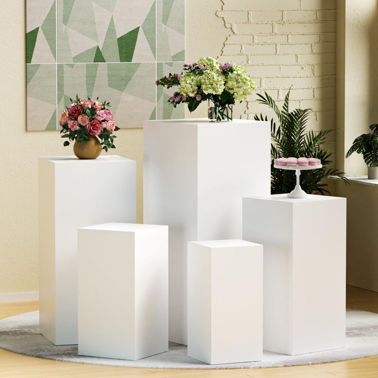 three white vases with flowers in them sitting on a round rug next to a brick wall