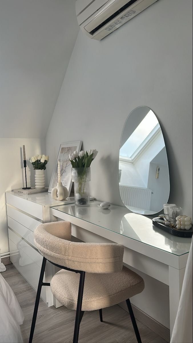 a bedroom with a vanity, mirror and stool