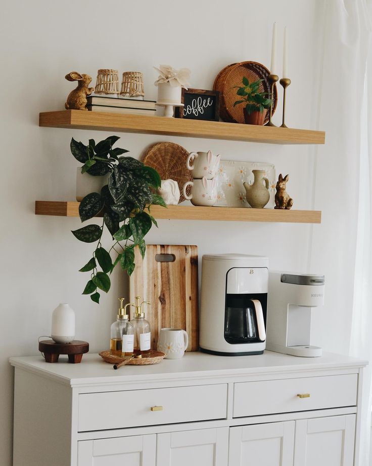 a coffee maker on top of a white dresser next to two wooden shelves filled with cups and mugs