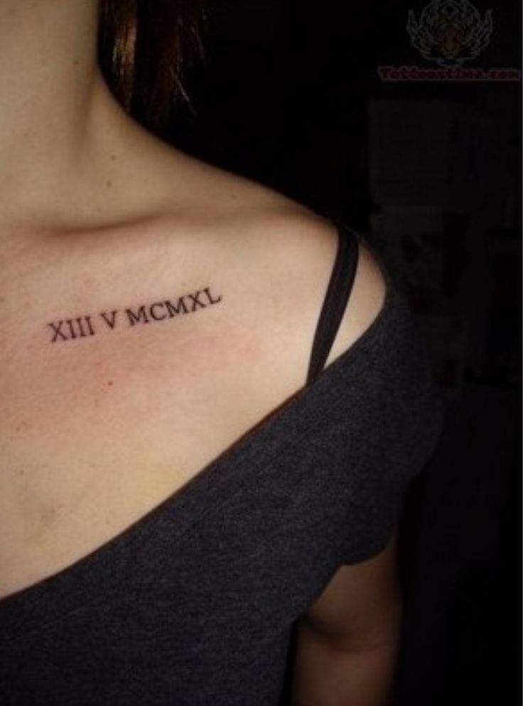 a woman with a small tattoo on her shoulder saying xiii v mcmxl