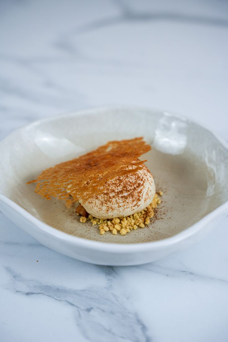 a white plate topped with food on top of a marble countertop covered in powdered sugar