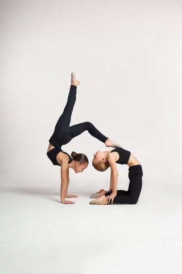 two young women doing yoga poses against a white background