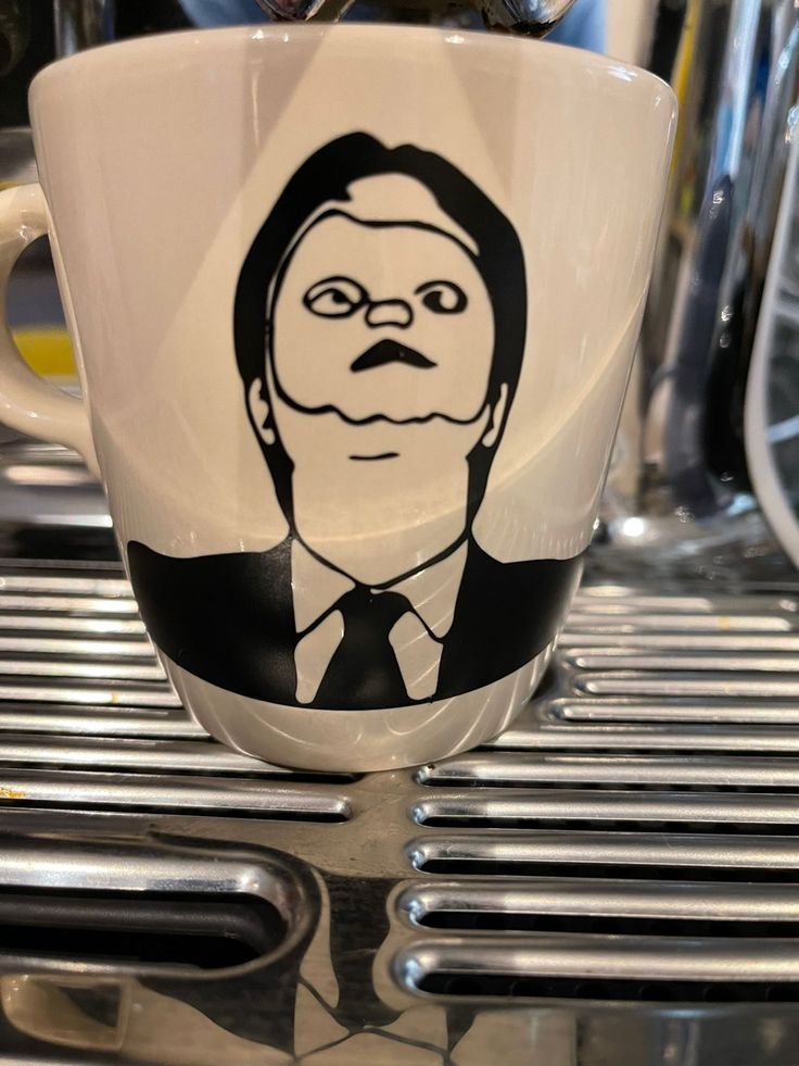 a coffee cup with a drawing of a man's face on the inside of it