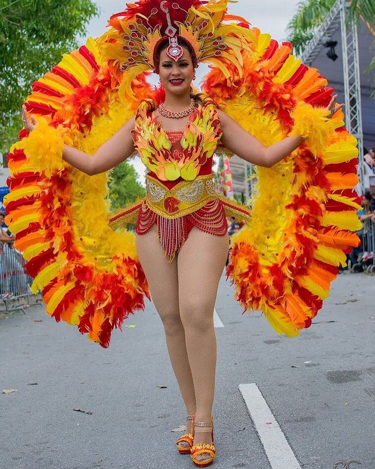 a woman in a red and yellow costume walking down the street with her hands on her hips