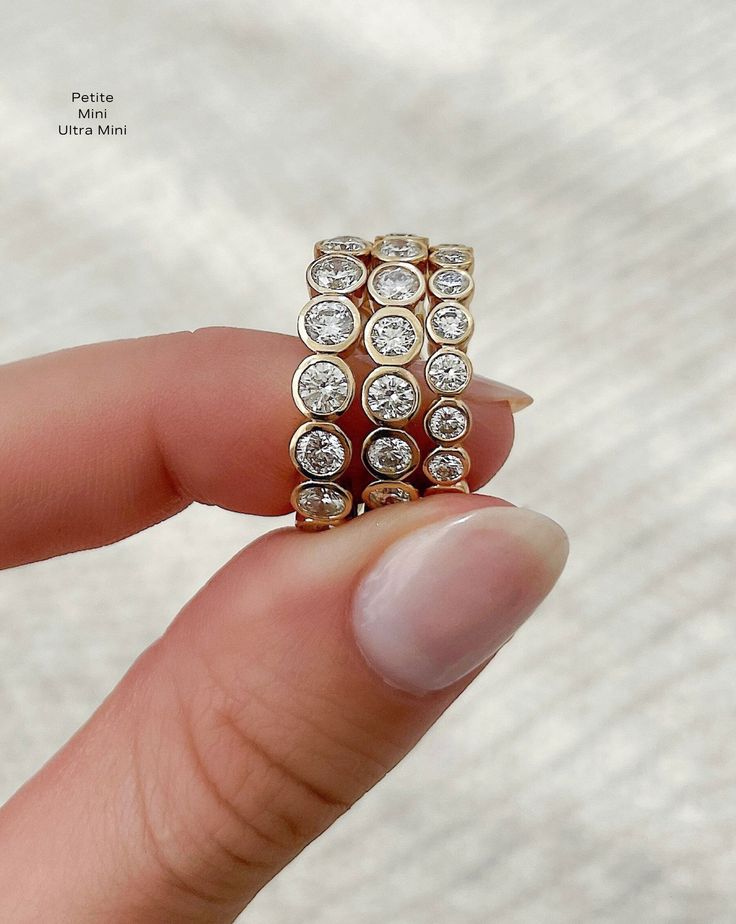 a person holding a ring with diamonds on it