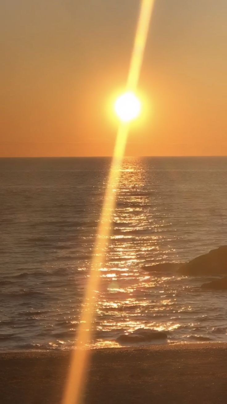 the sun is setting over the ocean and it looks like something from another planet or space