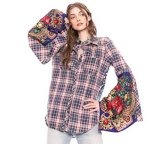 a woman is posing with her hands on her head while wearing a plaid shirt and jeans