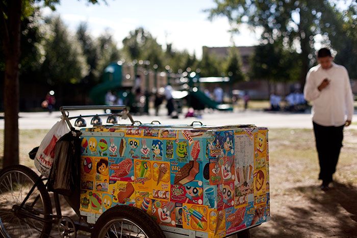 an ice cream cart is parked in the park