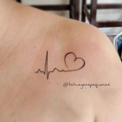 a woman's back with a heart and heartbeat tattoo on her left side shoulder