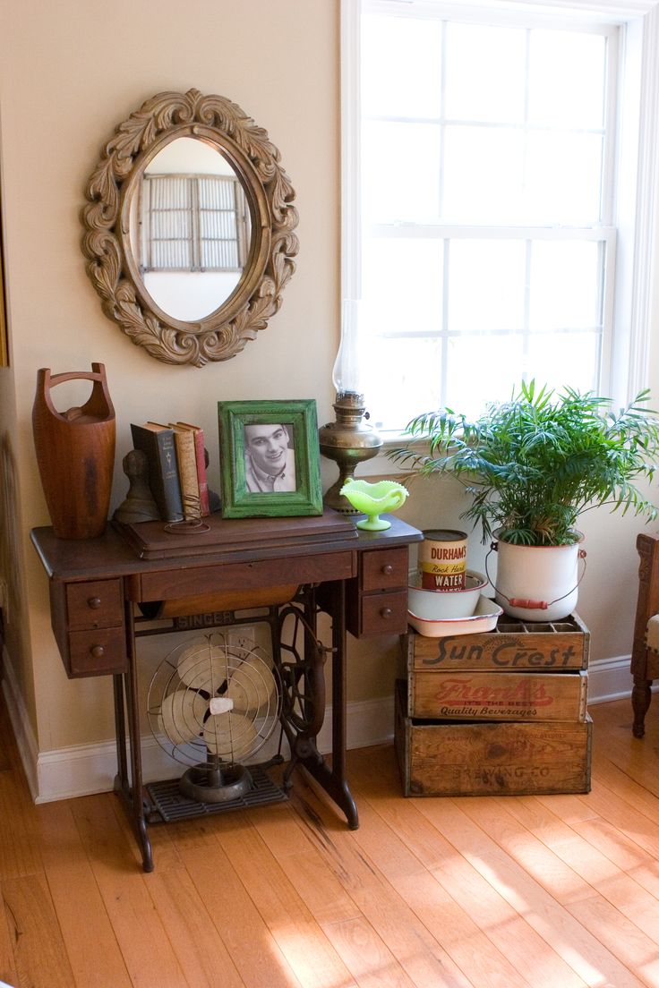 a room with a table, mirror and plant in it