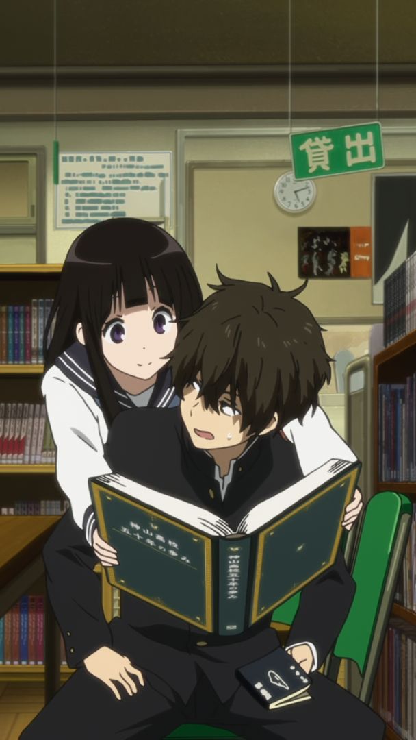 two people sitting on a chair reading books