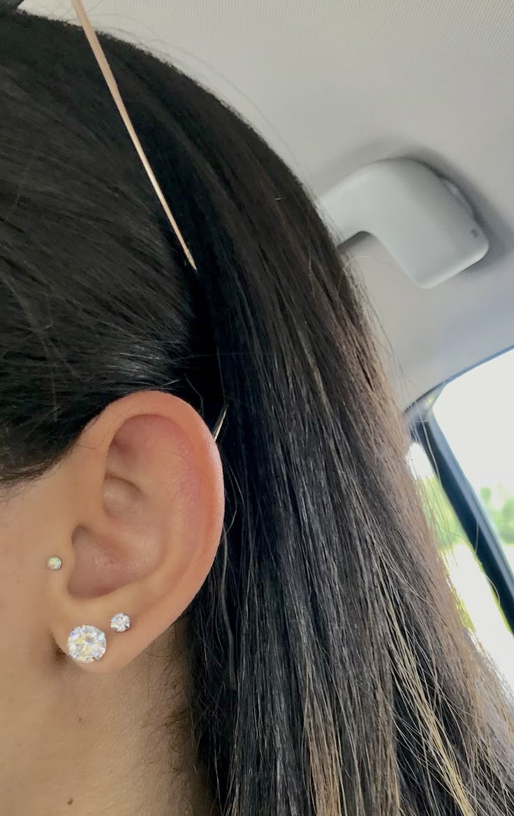 a woman with ear piercings in the back seat of a car