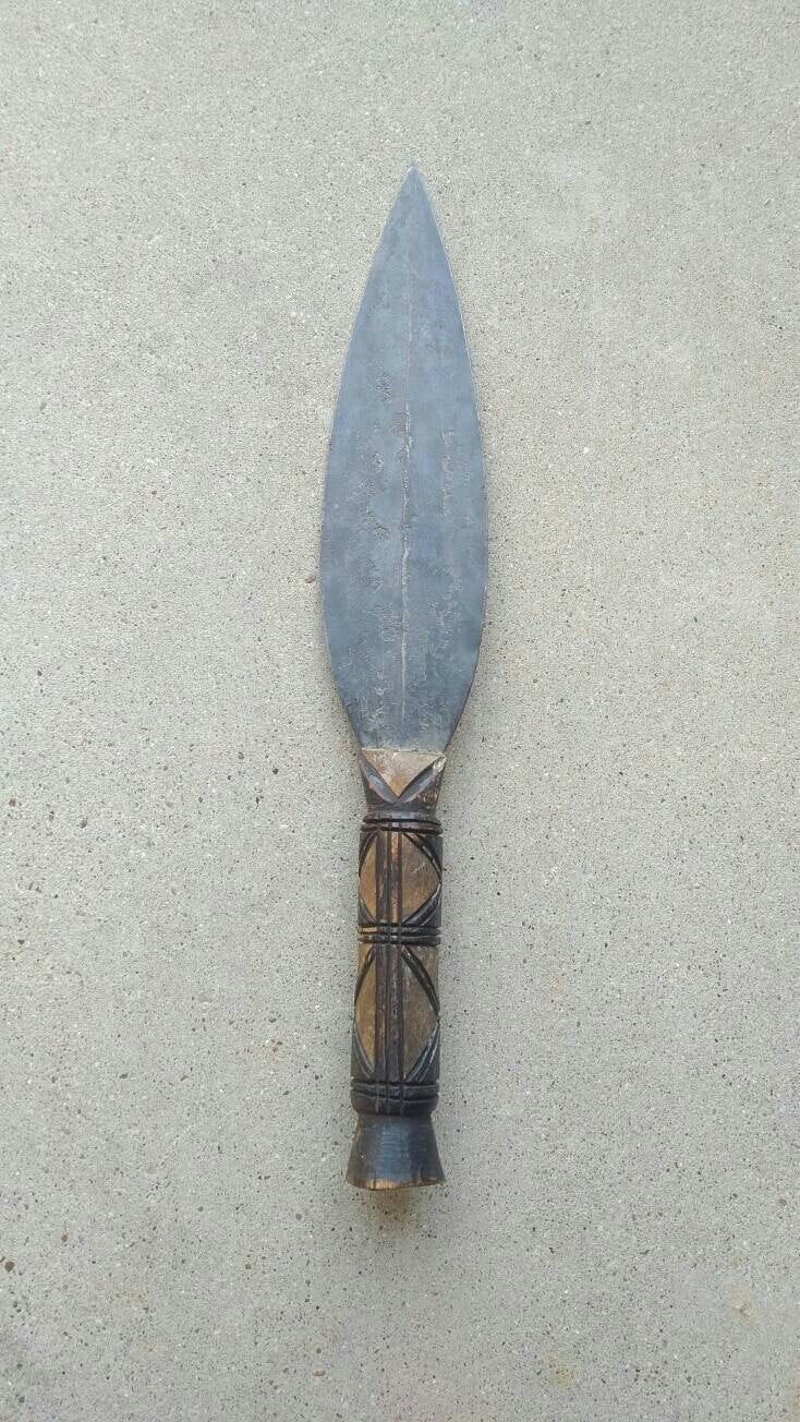 a knife that is laying on the ground with it's blade sticking out of it