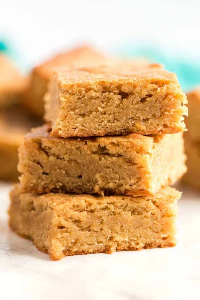 three pieces of peanut butter blondies stacked on top of each other in front of the camera