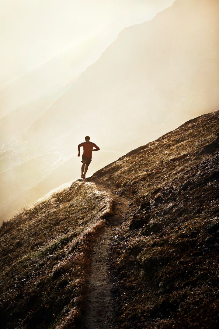 a man standing on top of a grass covered hill