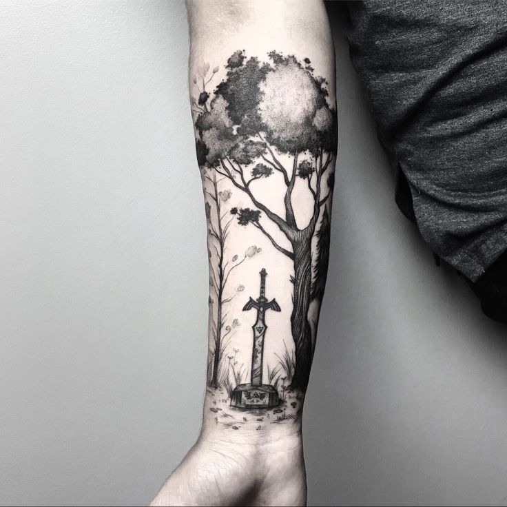 a man's arm with a tree and giraffe in the woods on it