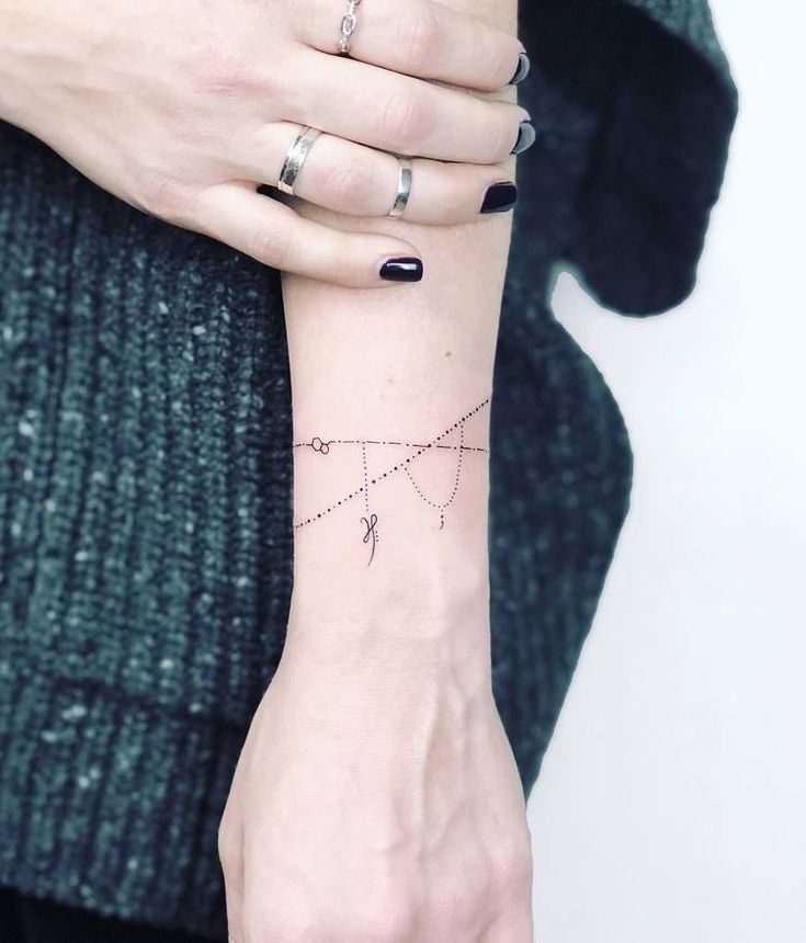 a woman's arm with a tattoo on it that has an arrow in the middle