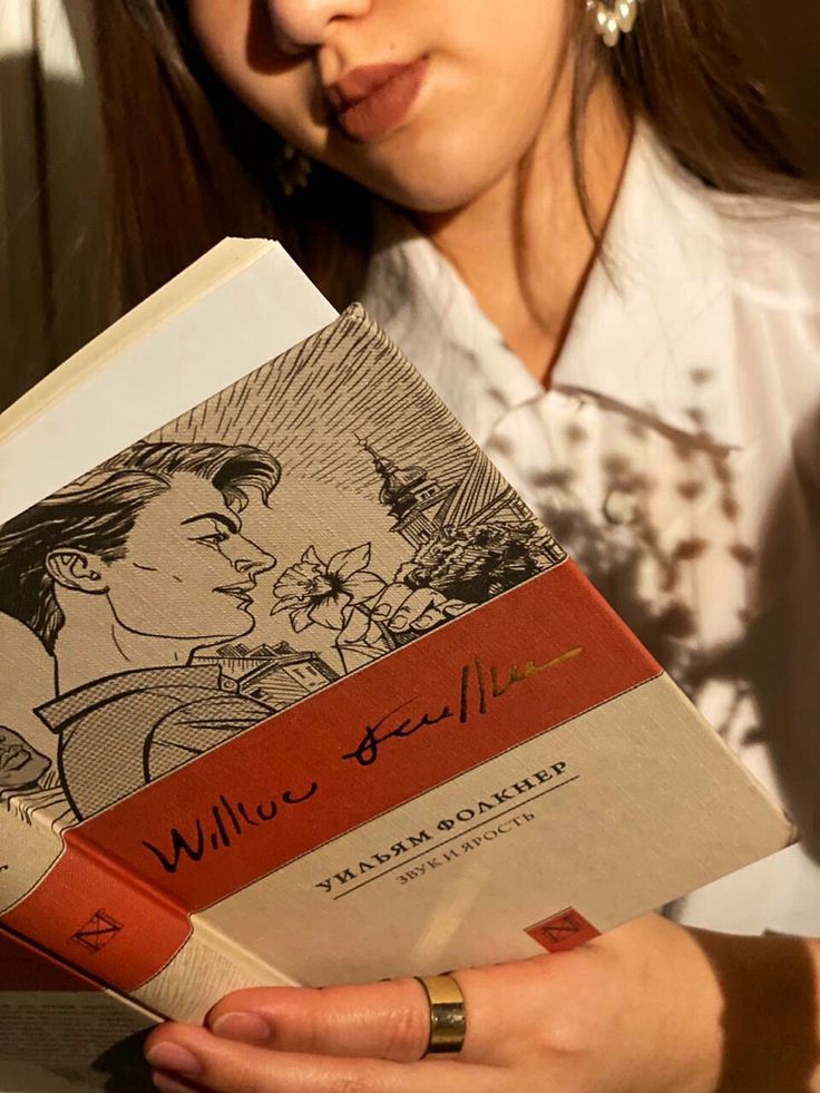 a woman holding a book with an image of a man kissing a woman's face