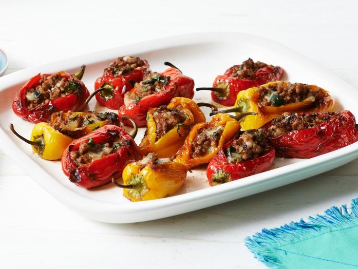 several stuffed peppers on a white platter