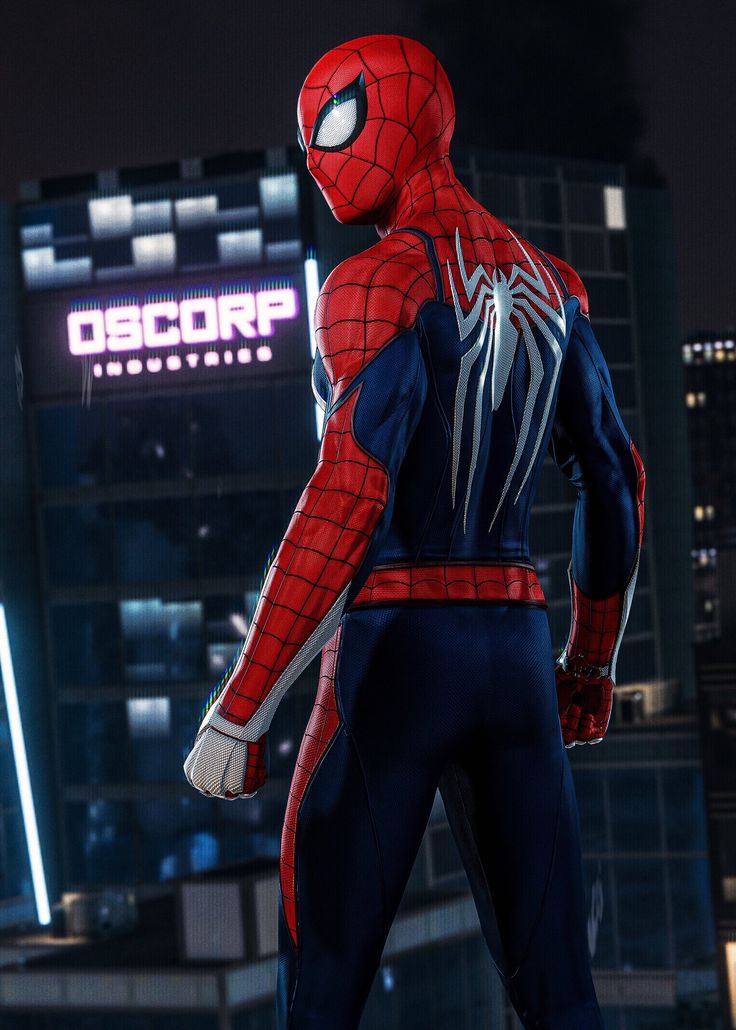 spider - man standing in front of a building at night